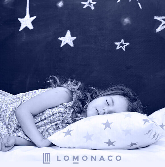 Una niña acostada en su colchón LoMonaco
