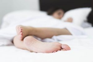 Persona-durmiendo-con-pies-destapados